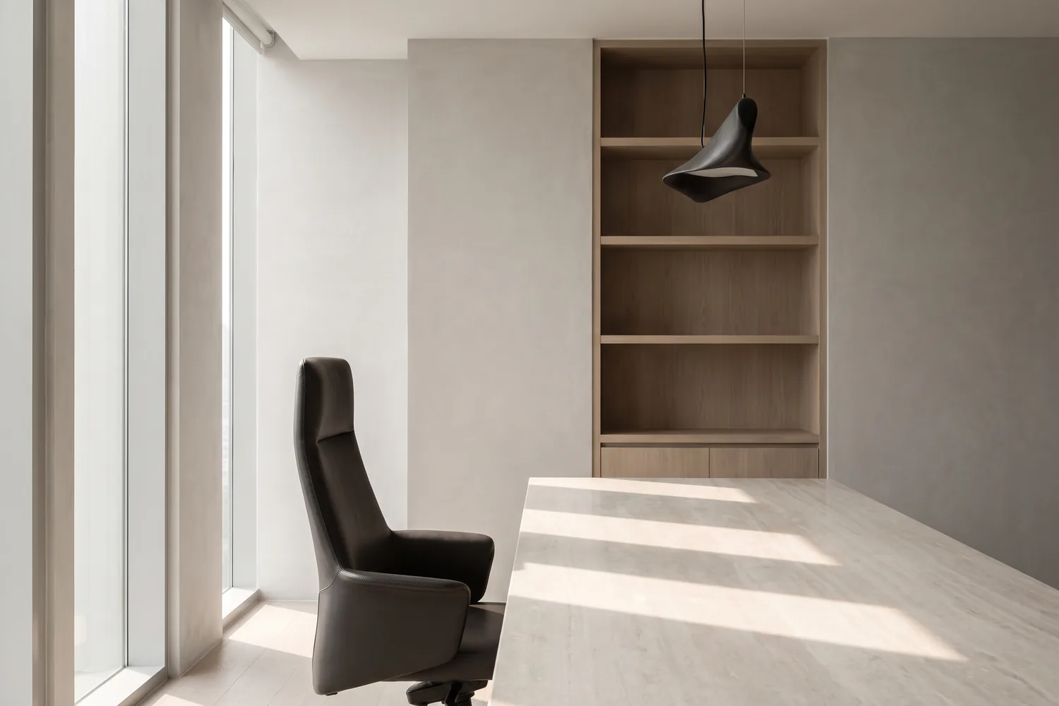 A calm, light-filled executive interior with a single chair and a long timber table
